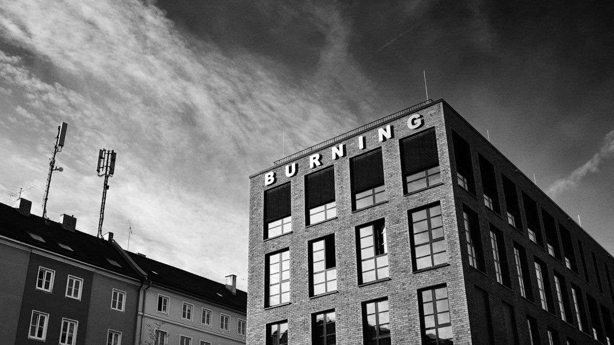 Modern building with 'burning' sign under a dramatic sky.